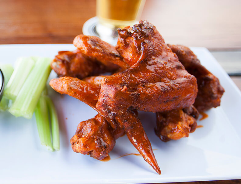 Perfectly cooked buffalo wings with a side of celery